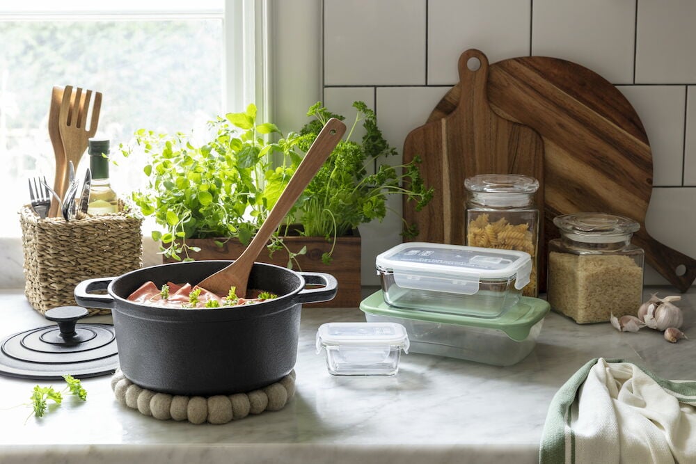 Svart gryta på beige grytunderlägg av ull.