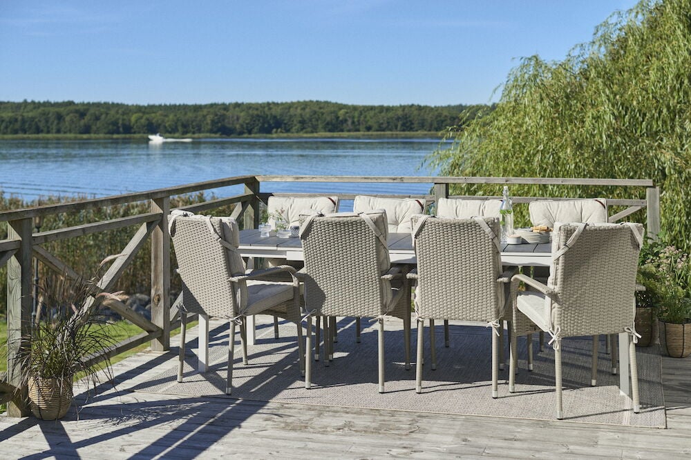 Vaaleanharmaa tyyny matalan selkänojan ulkotuoliin.