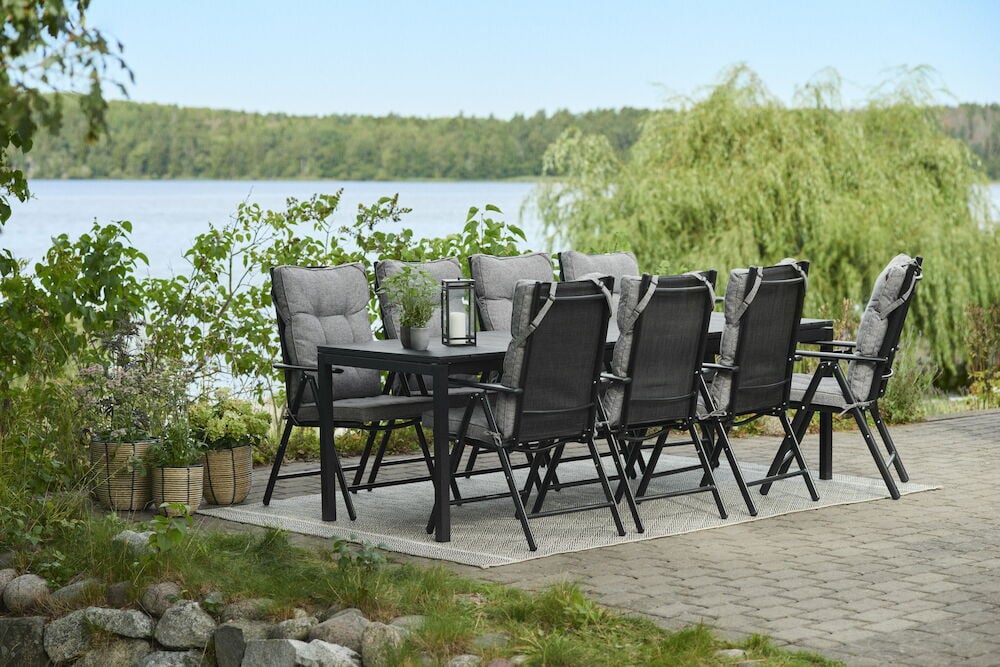 Harmaat tyynyt, joissa on korkea selkänoja ulkotuoleissa.