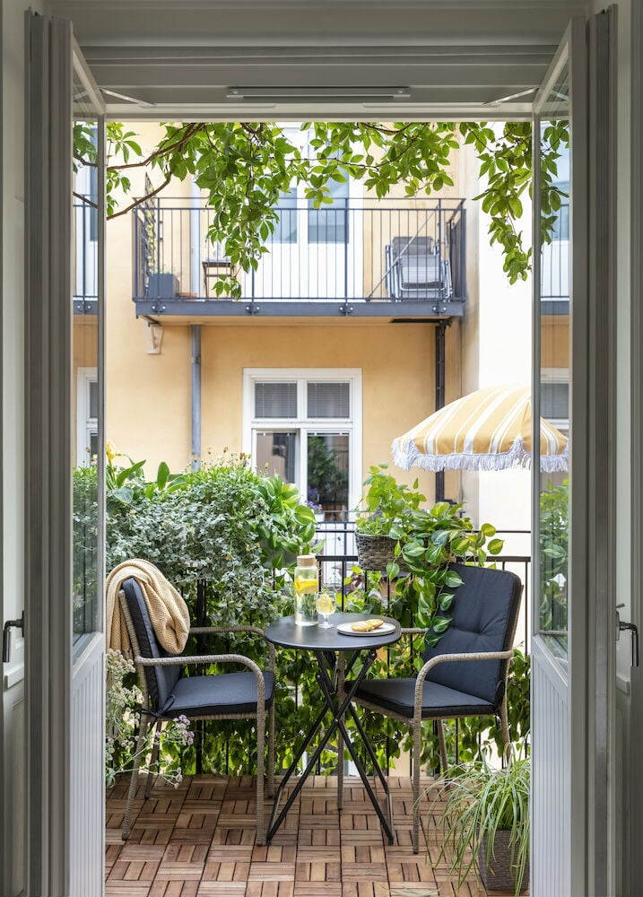 Två svarta utestolar med dynor på balkong.