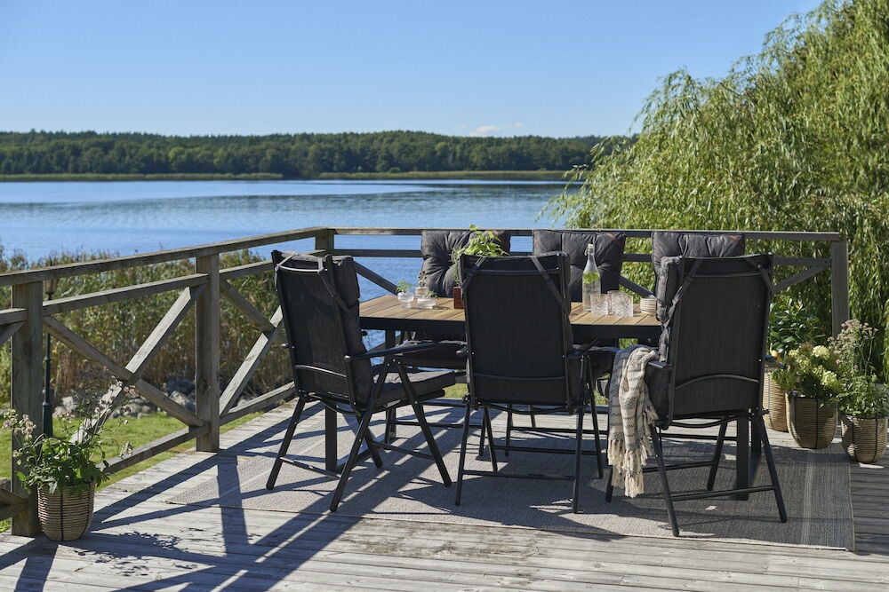 Mustat korkeaselkäiset pehmusteet terassin ulkokalusteisiin.