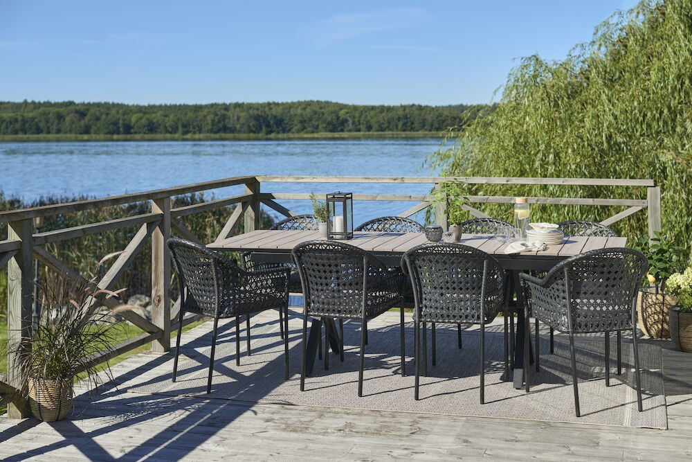 Ulosvedettävä musta ruokapöytä, jossa kahdeksan tuolia ulkokäyttöön.
