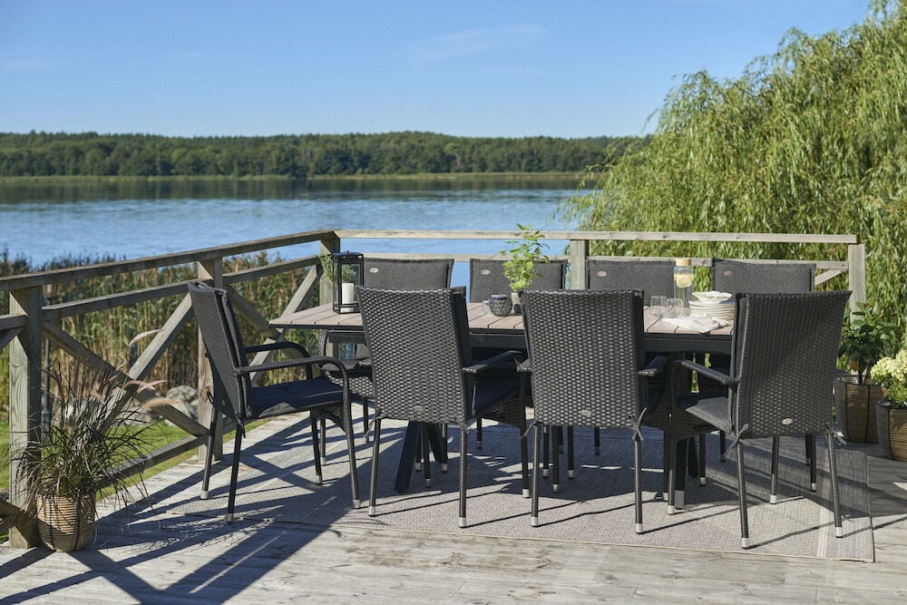 Svart utdragbart bord med åtta stolar på altan.