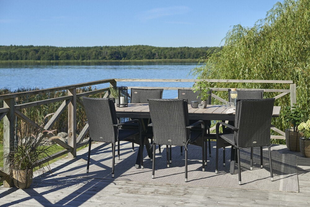 Svart utdragbart bord med sex stolar på altan.