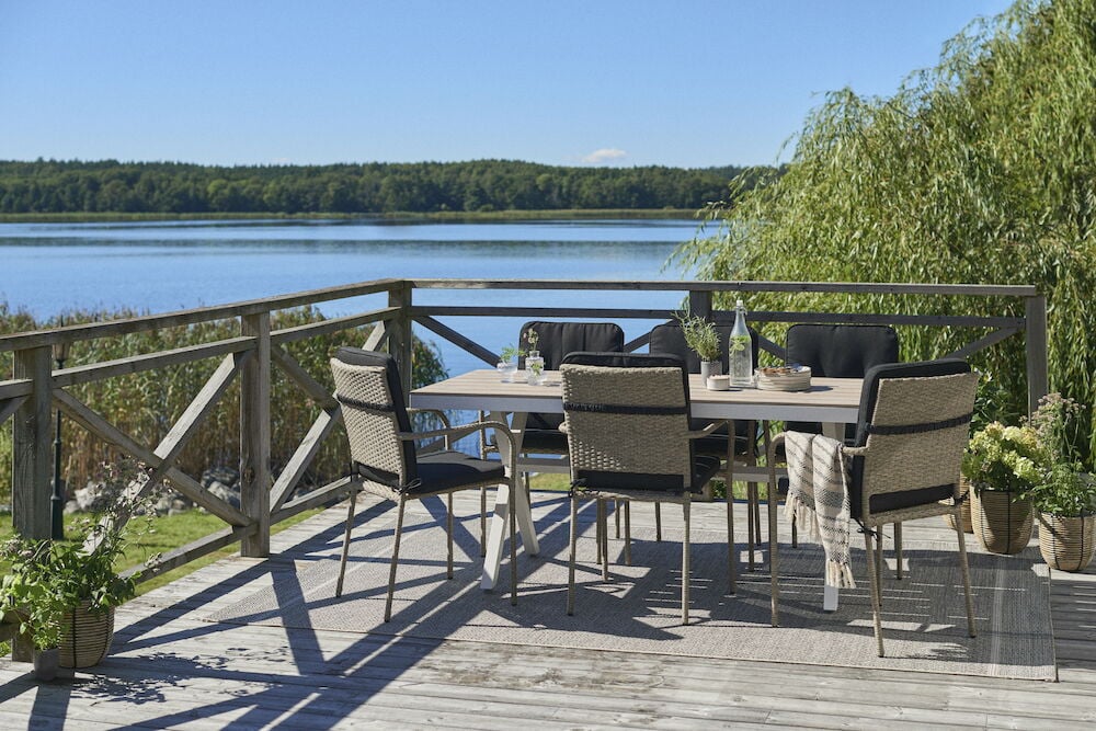 Vitt rektangulärt utomhusbord med sex stolar på altan.