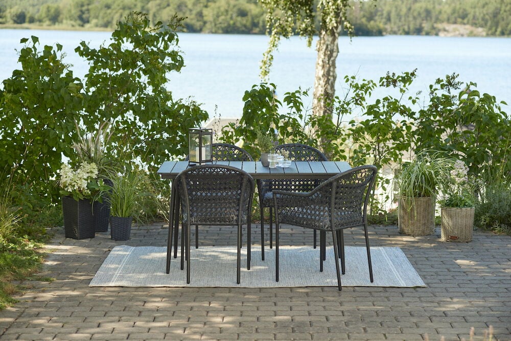 Musta ulkokalustesetti, jossa on neljä tuolia järven äärellä.