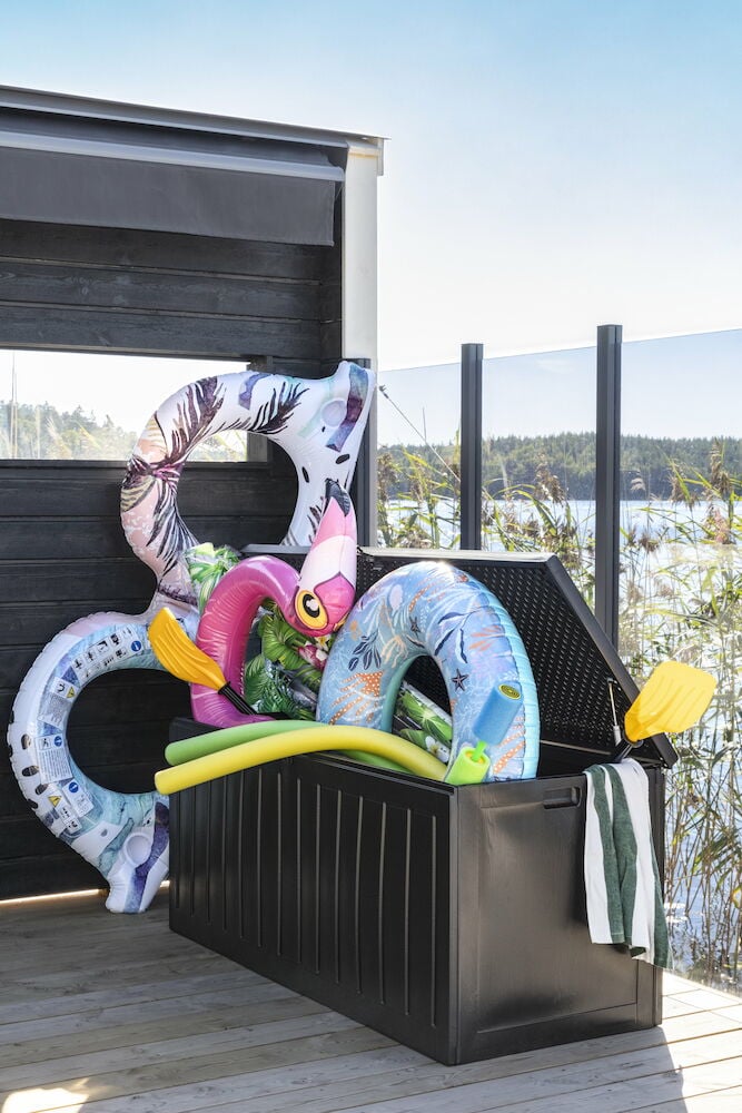 Stor svart förvaringslåda fylld med badleksaker.