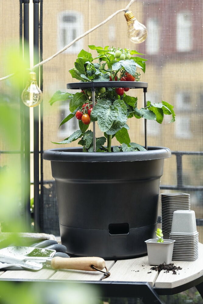 Fyrkantiga grå plastkrukor staplade på bordet.