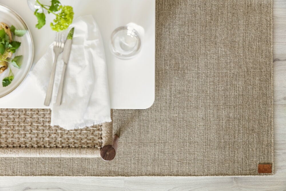 Brun matta under vitt matsalsbord med bestick.
