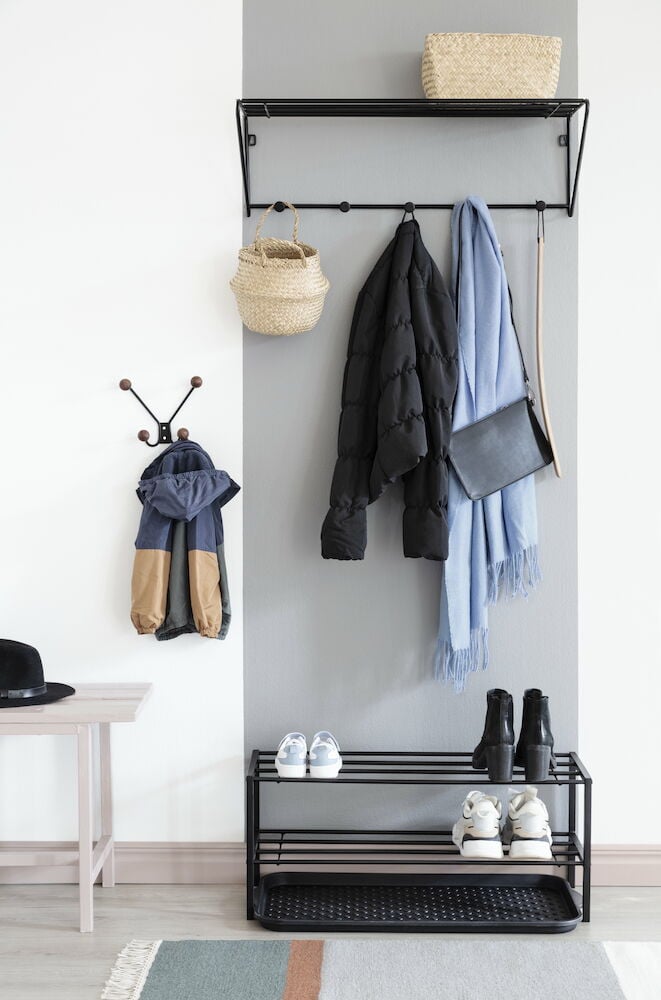 Koukut seinällä, joissa on takki ja lastenvaatteet.