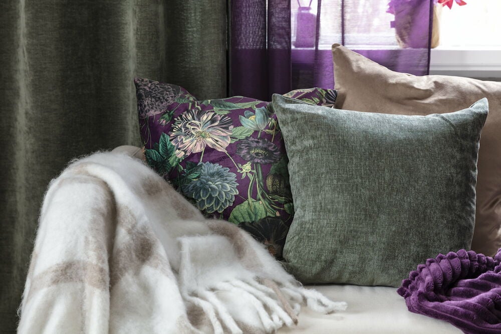 Mörkgrönt kuddfodral på vit bakgrund.