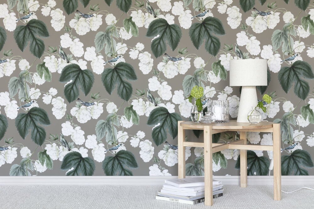 Tapet med små fåglar och gröna blad.