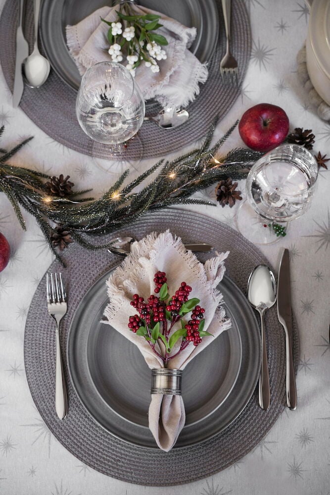 Två vinglas på dukat bord med juldekoration.