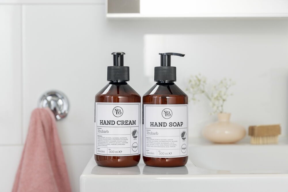 Brun flaska handkräm med svart pump på handfat.