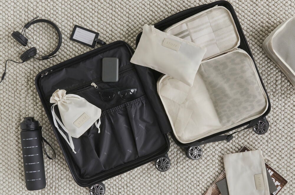 Svart kabinväska öppen med organiserade förvaringspåsar.