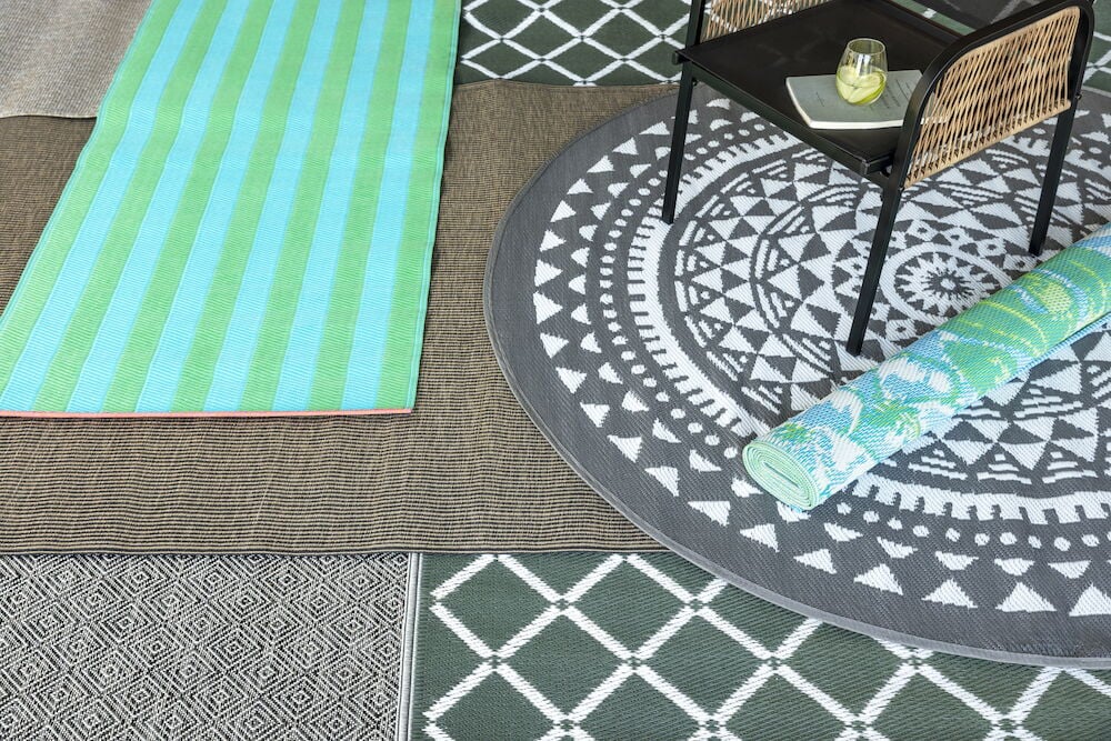 Rund antracitgrå bastmatta under svart stol.