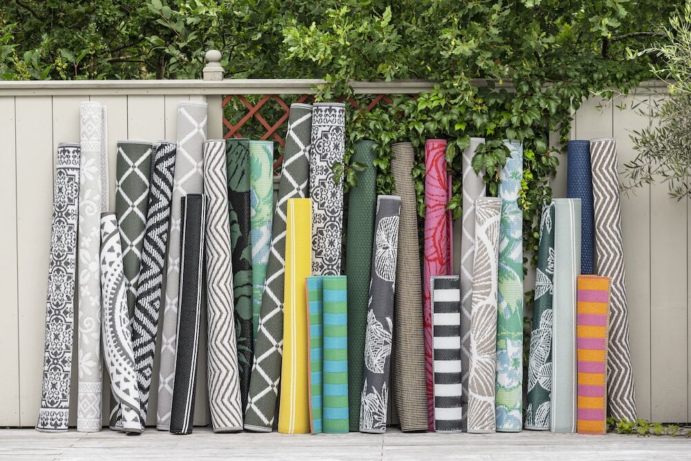 Flera hoprullade mattor i olika färger och mönster.