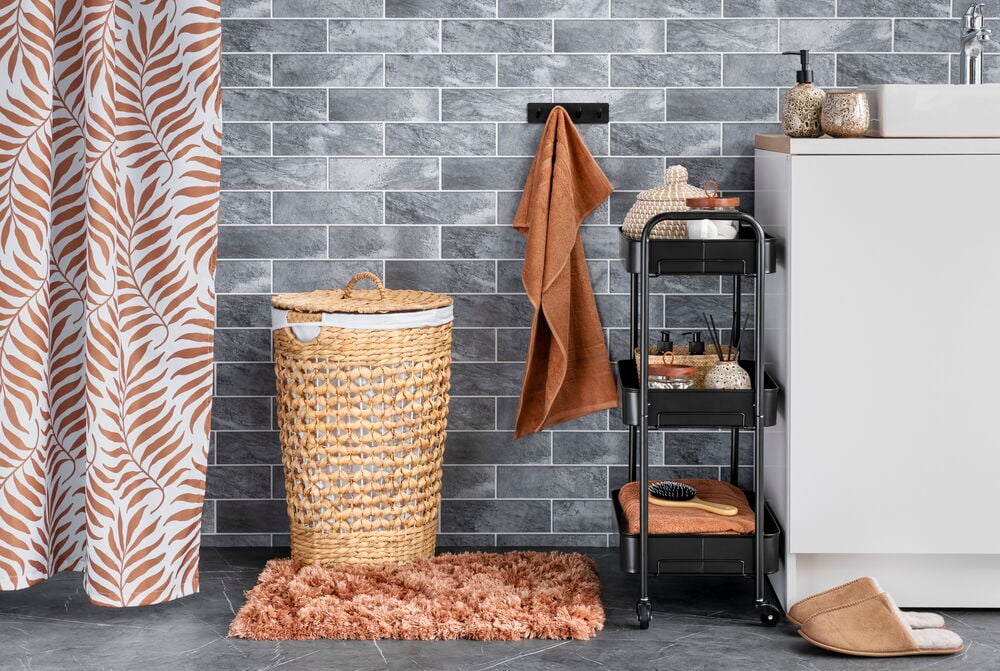 Mjuk pecanbrun shaggy badrumsmatta på grått klinkergolv.