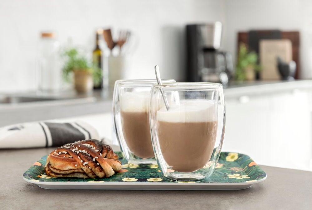 Två dubbelväggade glas med kaffe på en bricka.