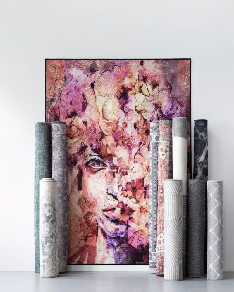 Harmaa tuftattu käytävämatto rullattu valkoista seinää vasten.