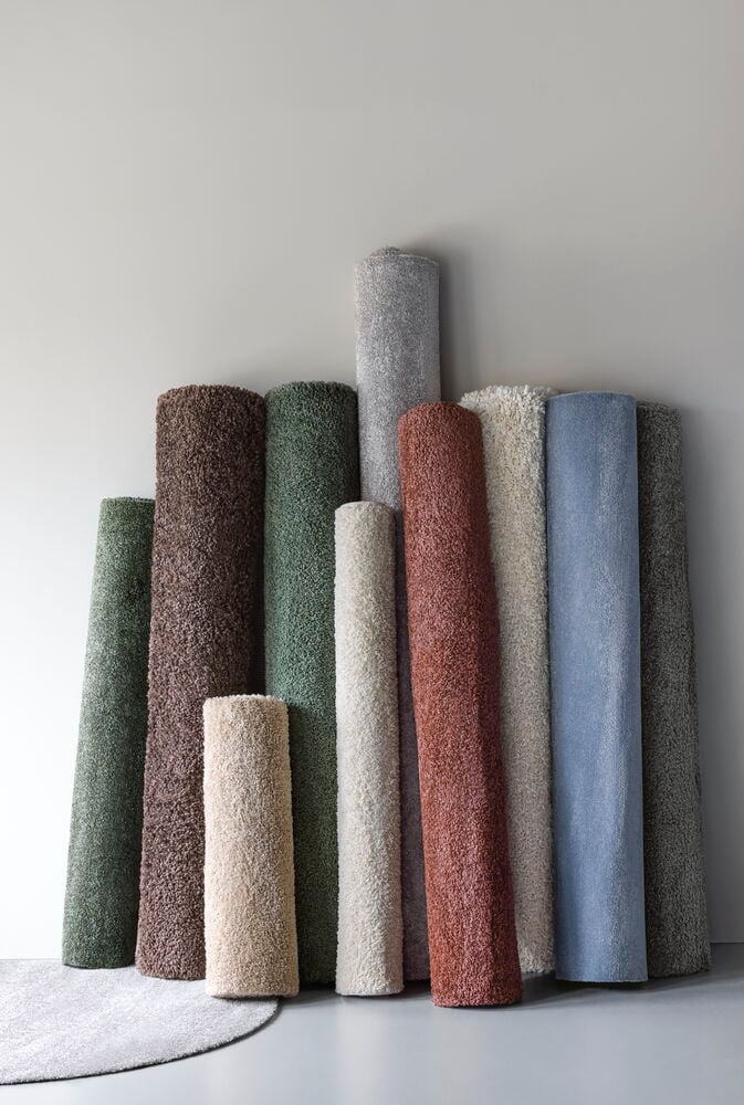 Stående rullar av mjuka mattor i olika färger.