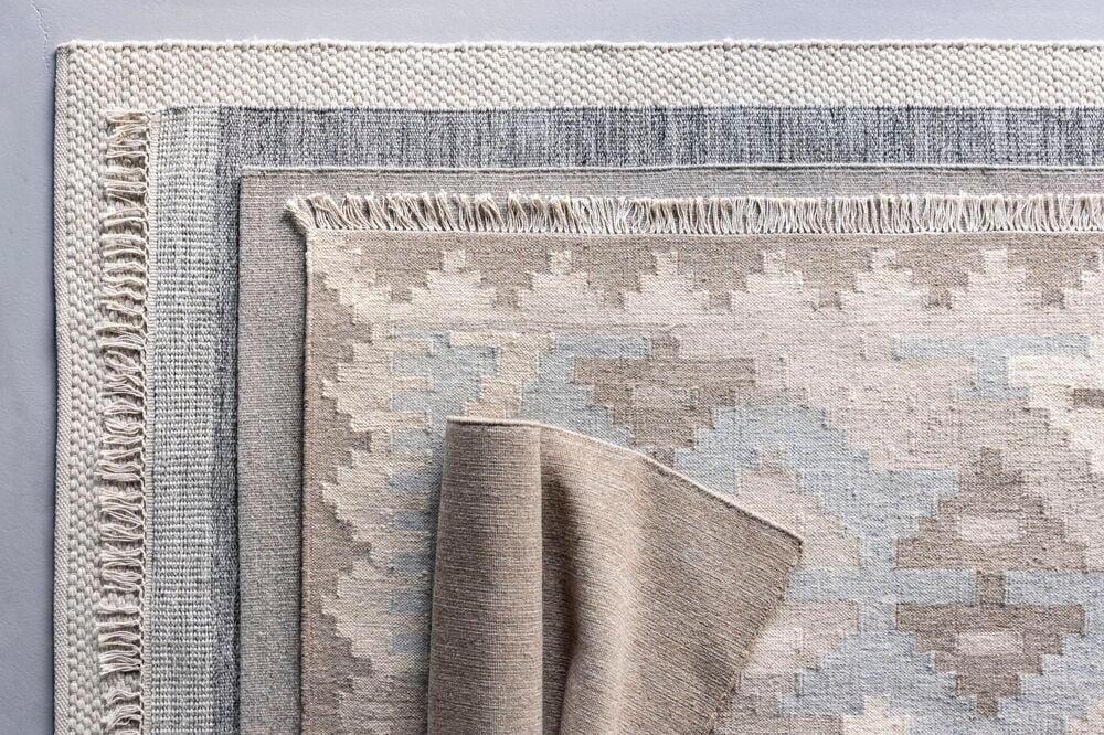 Handgewebter grauer Teppich aus Wollmischung mit Fransen.