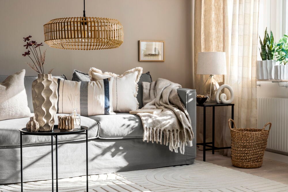 Hopfällbar vattenhyacintkorg i vardagsrum bredvid soffa.