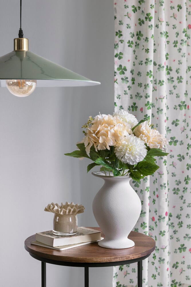 Ljusgröna gardinlängder med rosa klöverblommor.