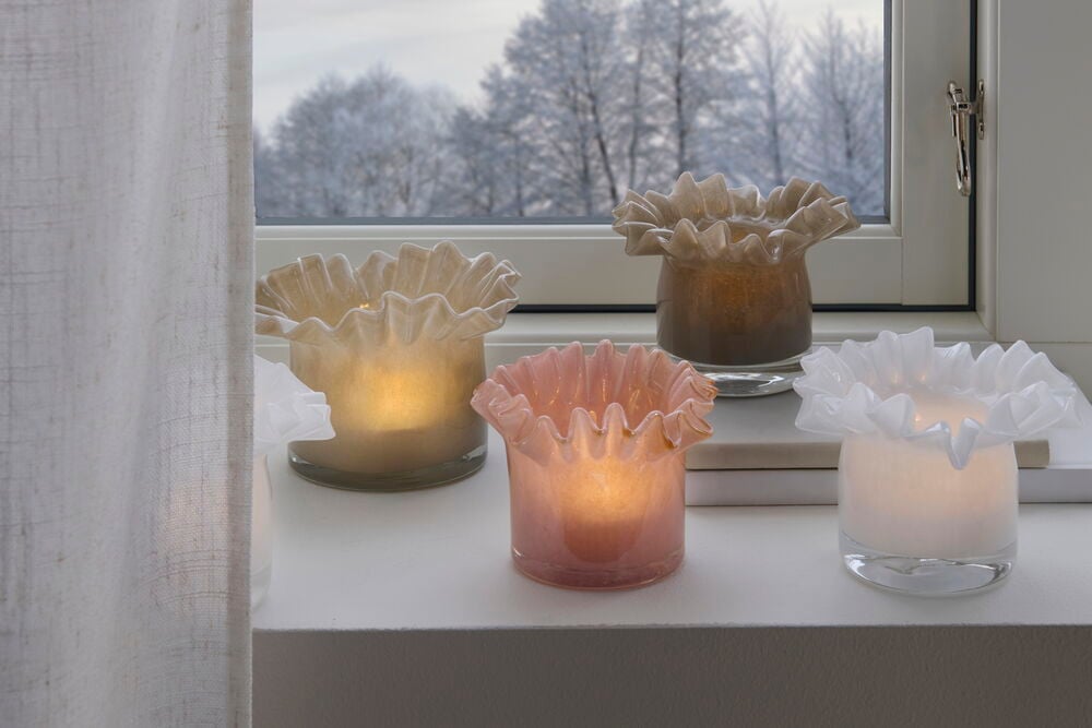 Valkoinen tuikkukynttilänpidike lasista, jossa on taiteellinen orgaaninen muoto.