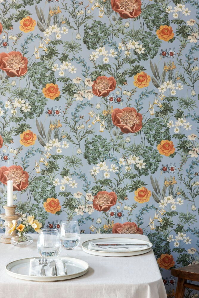 Vaaleita kukkia niittykuviolla, vaaleansininen tausta.