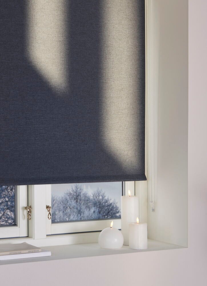 Valoa päästävä ikkuna harmaabeige pimennysrullaverho.