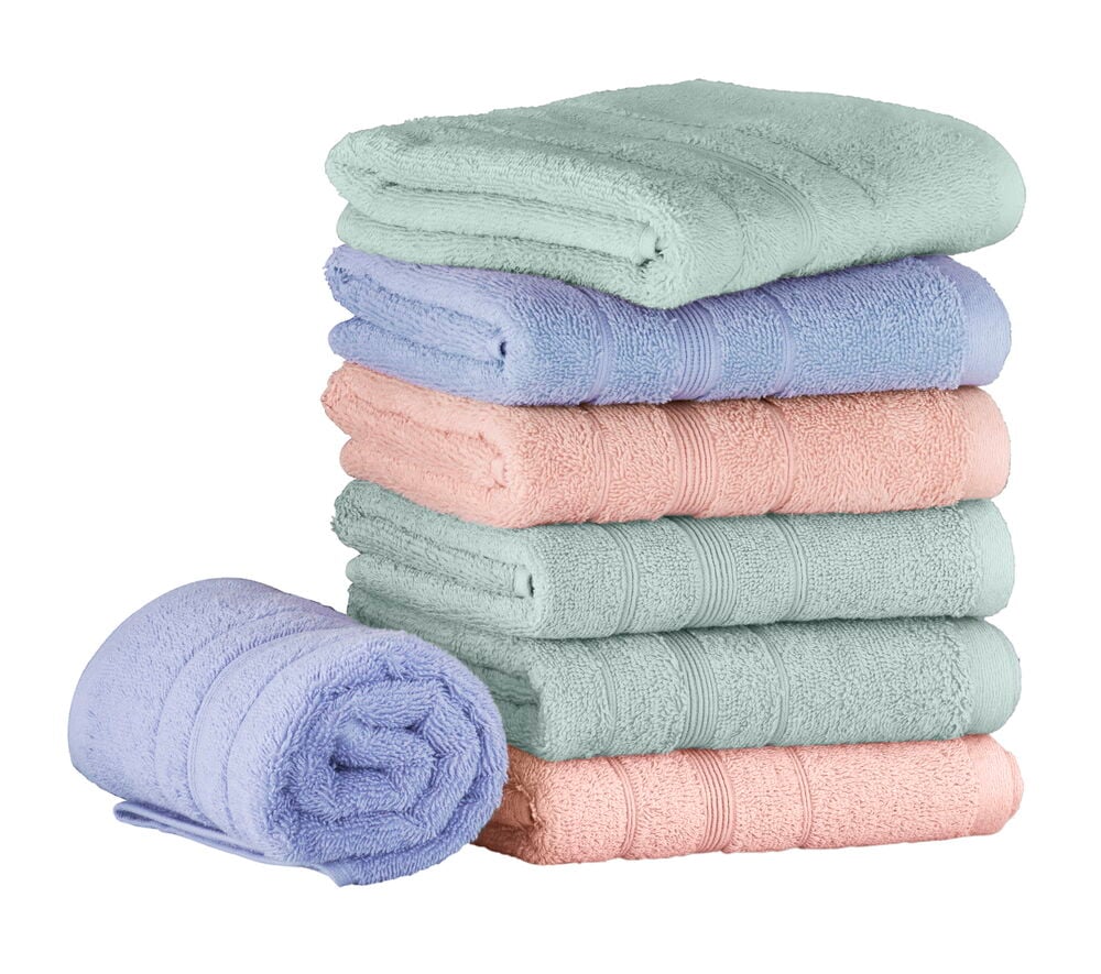 En stapel handdukar i pastellfärger, en är rullad.