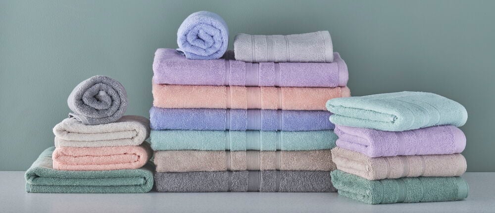 Flera vikta handdukar i pastellfärger på rad.