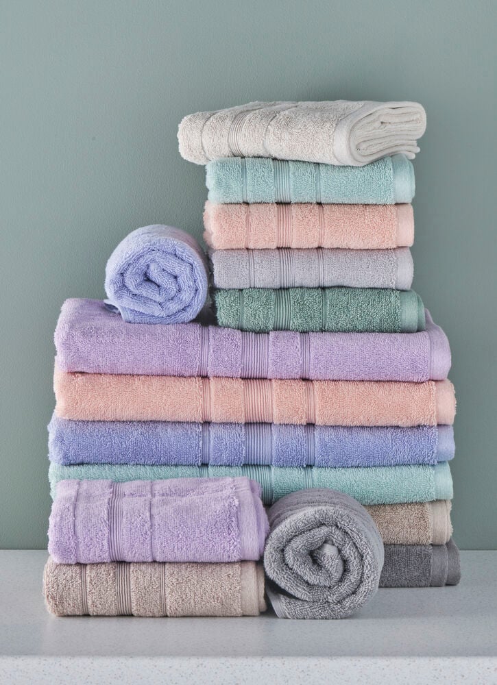 Staplade pastellfärgade handdukar i olika mjuka nyanser.