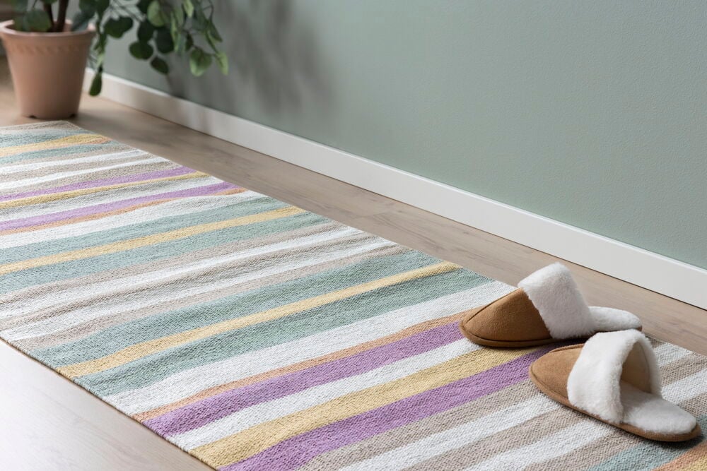 Hellgrüne Wand mit matter Oberfläche an der Fußleiste.