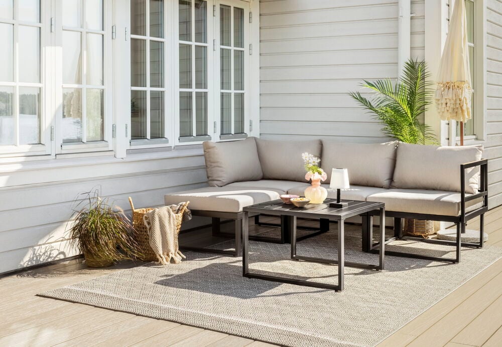 Aurinkokennovalo Ivö mustalla ulkopöydällä istuinryhmän kanssa.