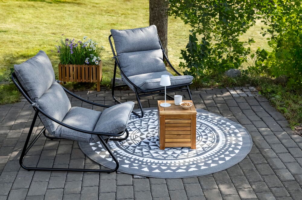 Förvaringspall i akaciaträ med naturfärgad dyna utomhus.