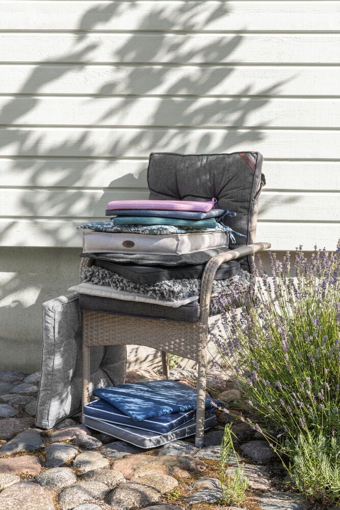 Useita istuintyynyjä ulkona olevassa puutarhatuolissa.