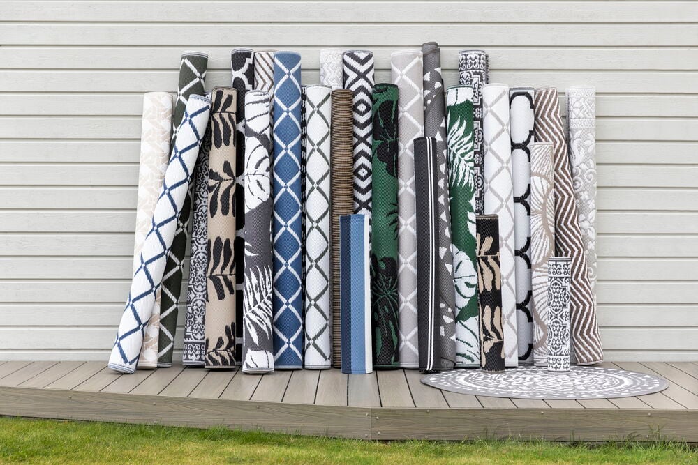 Flera upprullade mattor med olika mönster och färger.