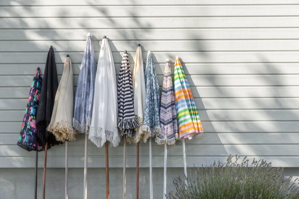 Useita eri väreissä ja kuvioissa olevia kokoon taitettuja aurinkovarjoja.