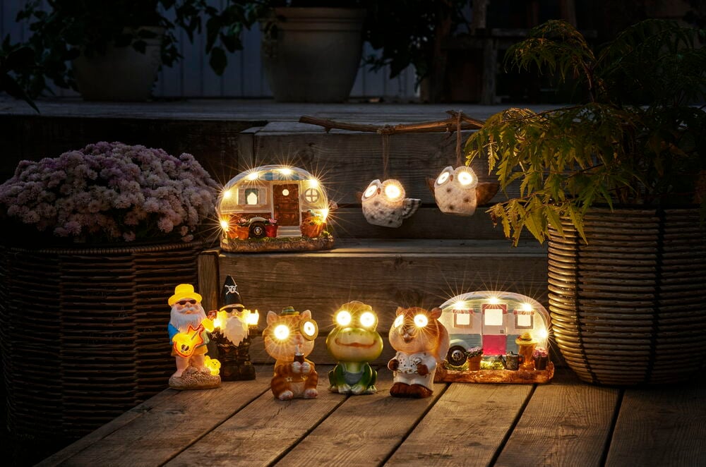 Flere små solcellefigurer lyser på en tretrapp.