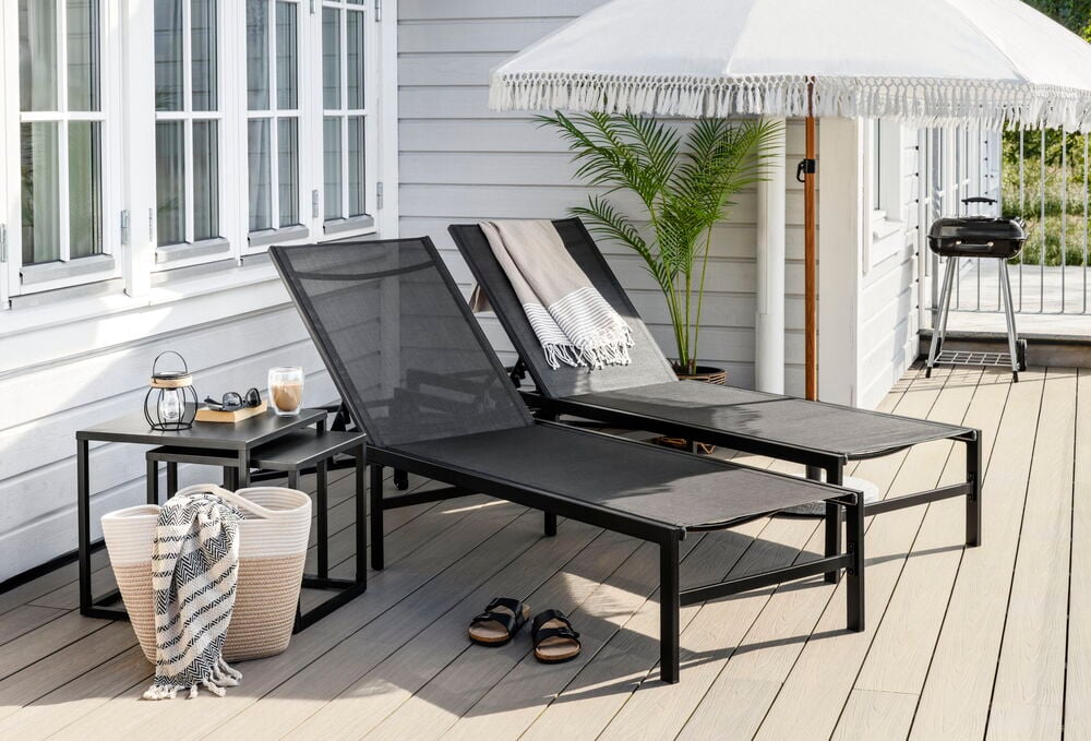 Två svarta sidobord i pulverlackerat stål utomhus.