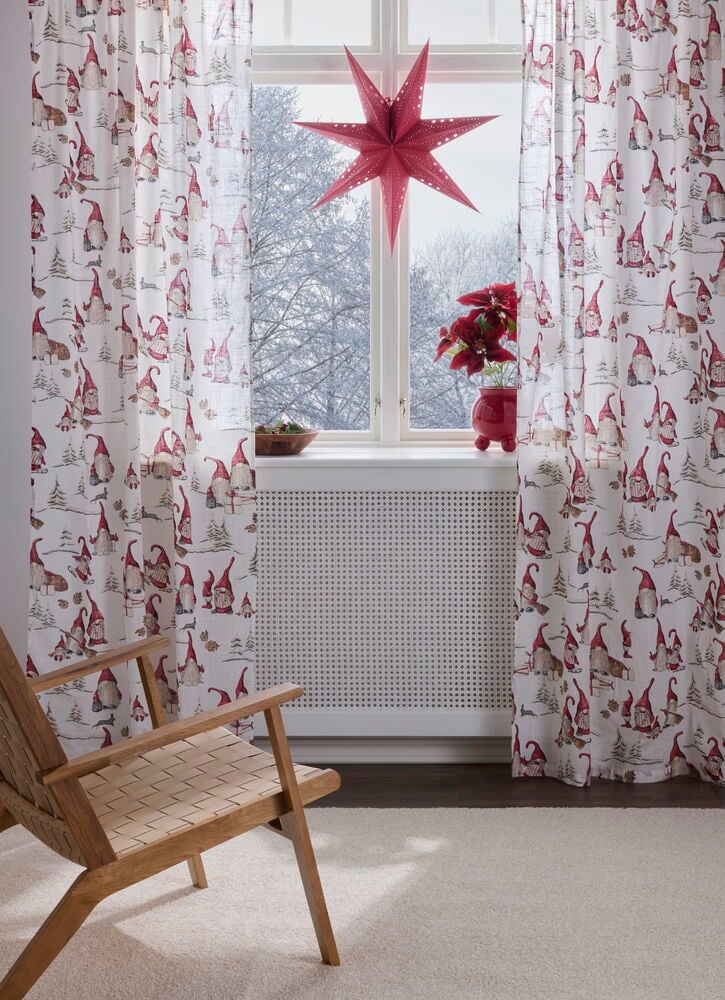Off-white Baumwollvorhänge Ljungby mit roten Wichteln und Baummuster, im Fenster hängend.