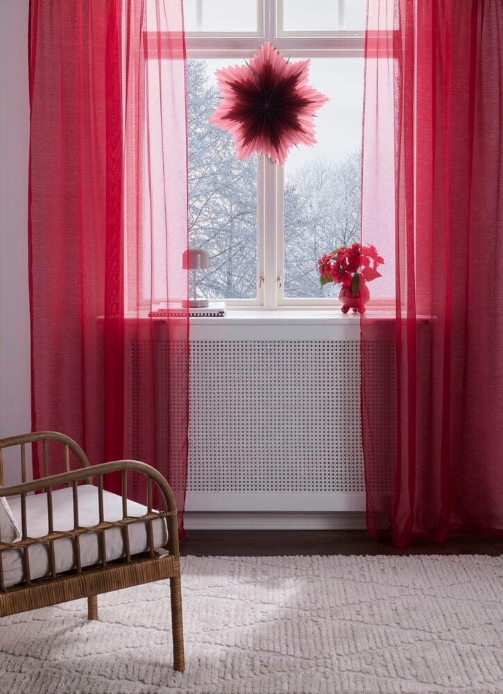 Kirschrosafarbene Polyester Gardinen Kim 135x220 cm hängen transparent an einem Fenster, filtern Licht ein.