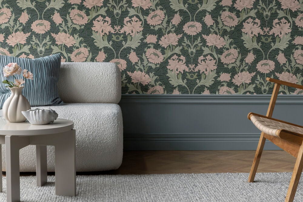 Tapete Boutique Curly Flowers Green Vlies mit rosa Blüten und grünen Blättern auf einer dunkelgrünen Wand.