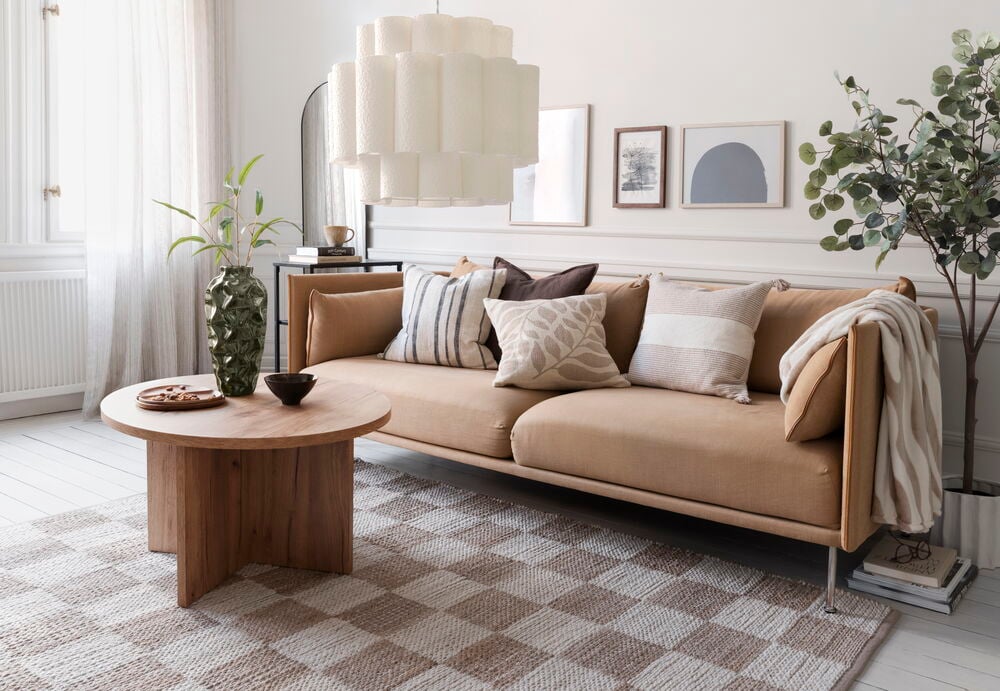 Pledd Zebra 125x150 cm Muldvarp Polyester, med hvite striper, drapert over lys brun sofa.