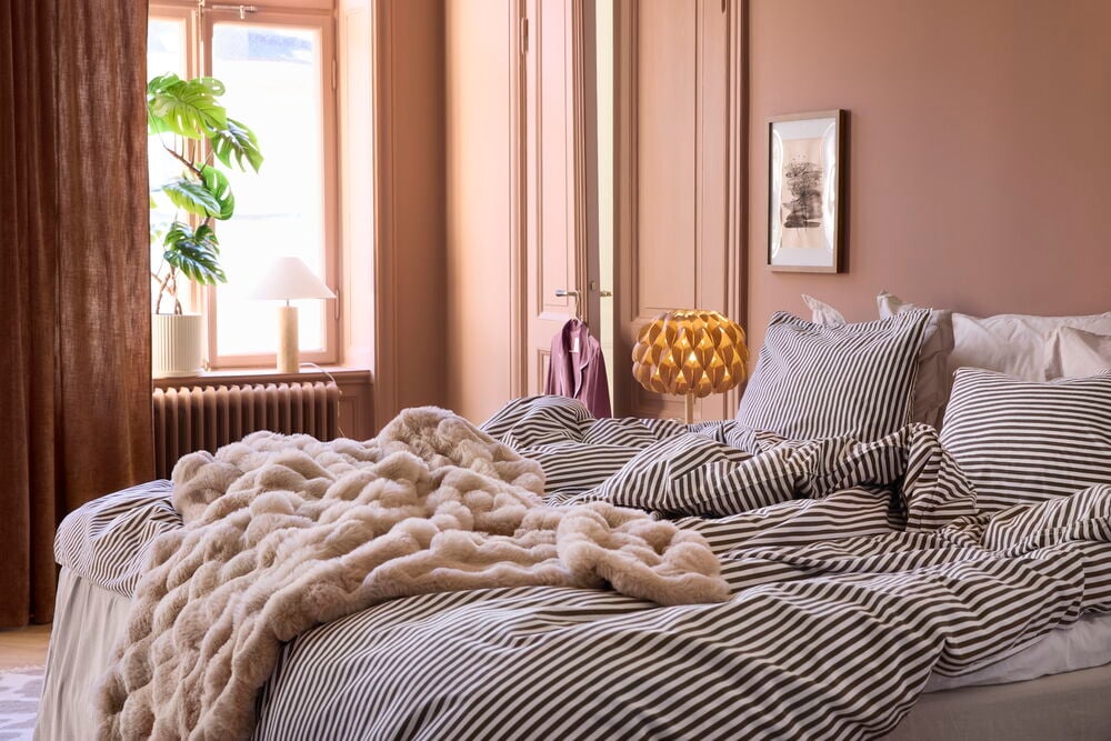 Konjakki polyesterisametti sivuverho, vaaleanruskea tekoturkistorkkupeitto ja violetti aamutakki ovessa.