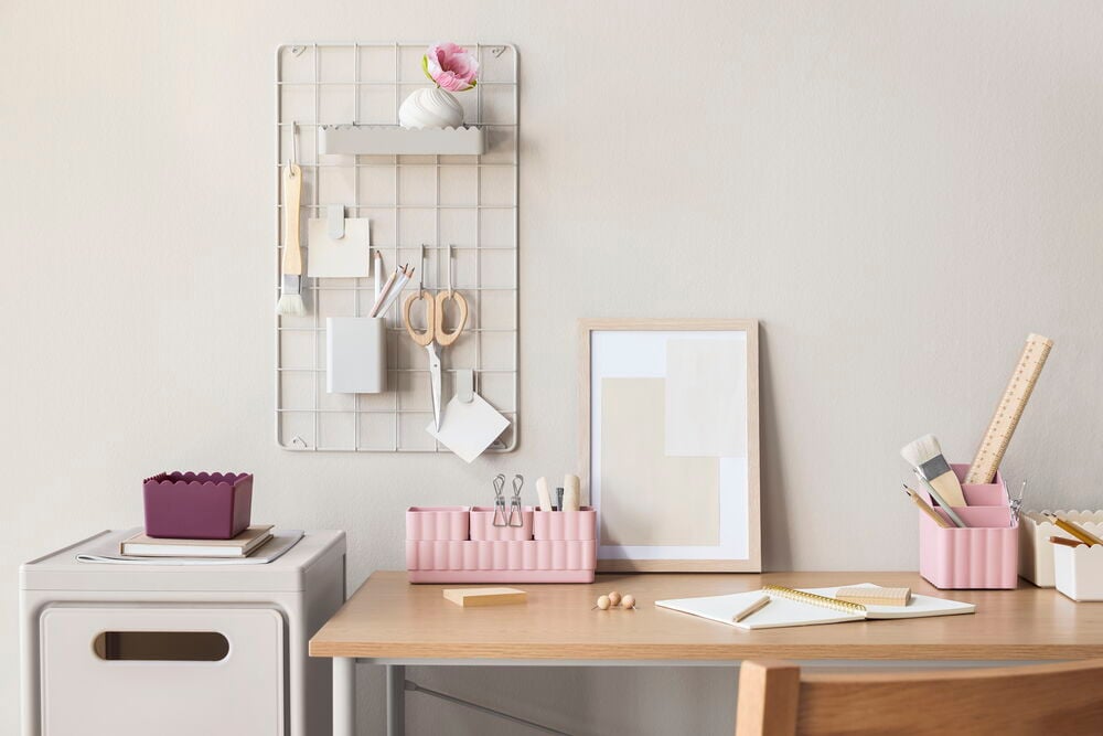 Beige stapelbar förvaringslåda, lila vågad låda, rosa förvaringar och en grå rutnätstavla.