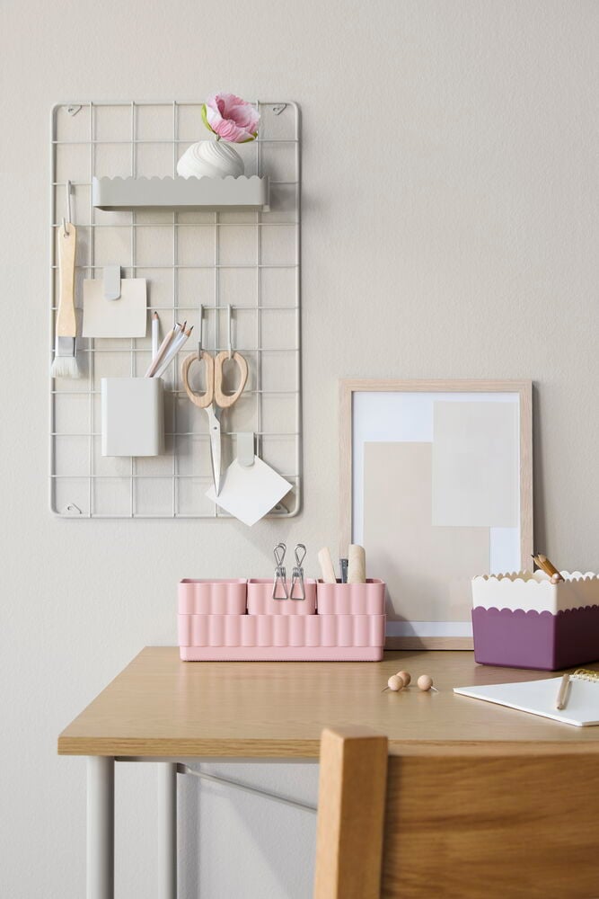 Beiges Notizgitter 30x50x0.5 cm mit grauem Regal, Blume, Stiftehalter, Schere, Notizen und pinken Schreibtisch-Organizern.
