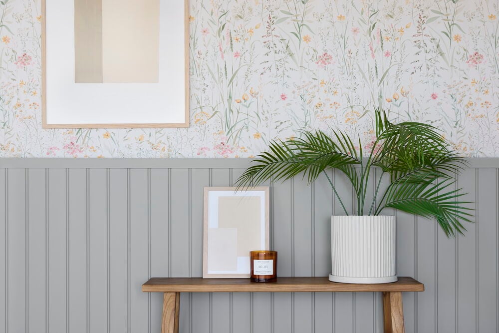 Tapete Boutique Free Flower Cream, eine cremefarbene Blumentapete mit zarten grünen, rosa und gelben Wildblumen.